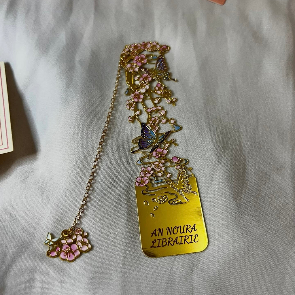 Élégant marque-page en acier inoxydable doré avec motifs de papillons ciselés. Un accessoire de lecture raffiné et durable, idéal pour offrir avec un livre.